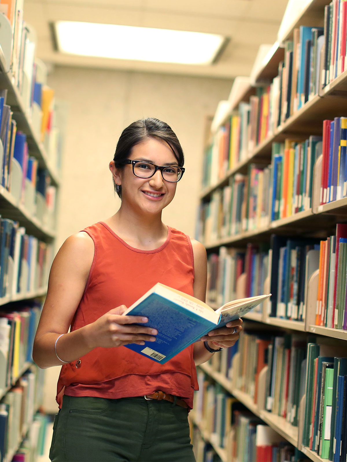 Student holding a book in library