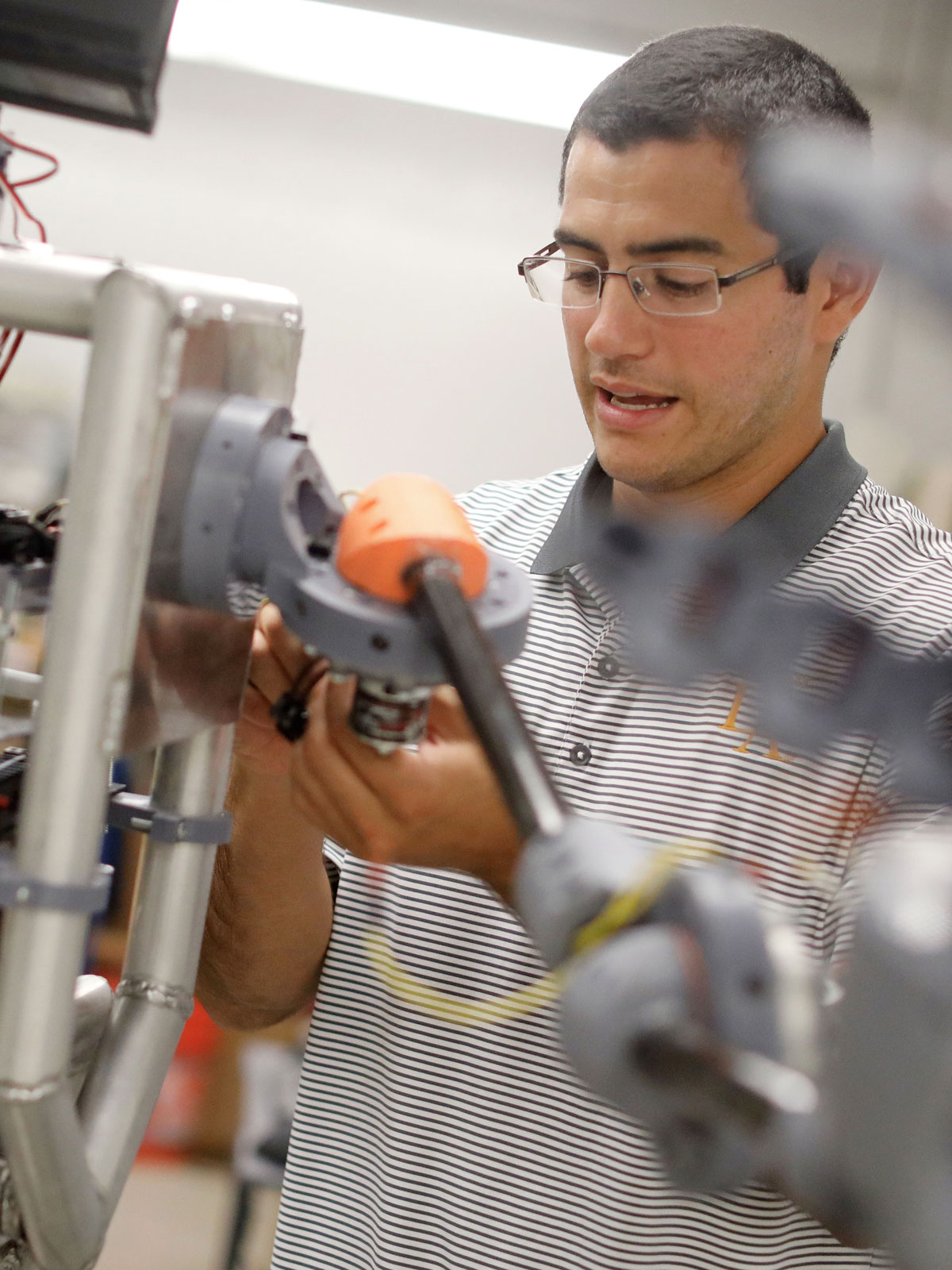 An engineering student works on a robot.